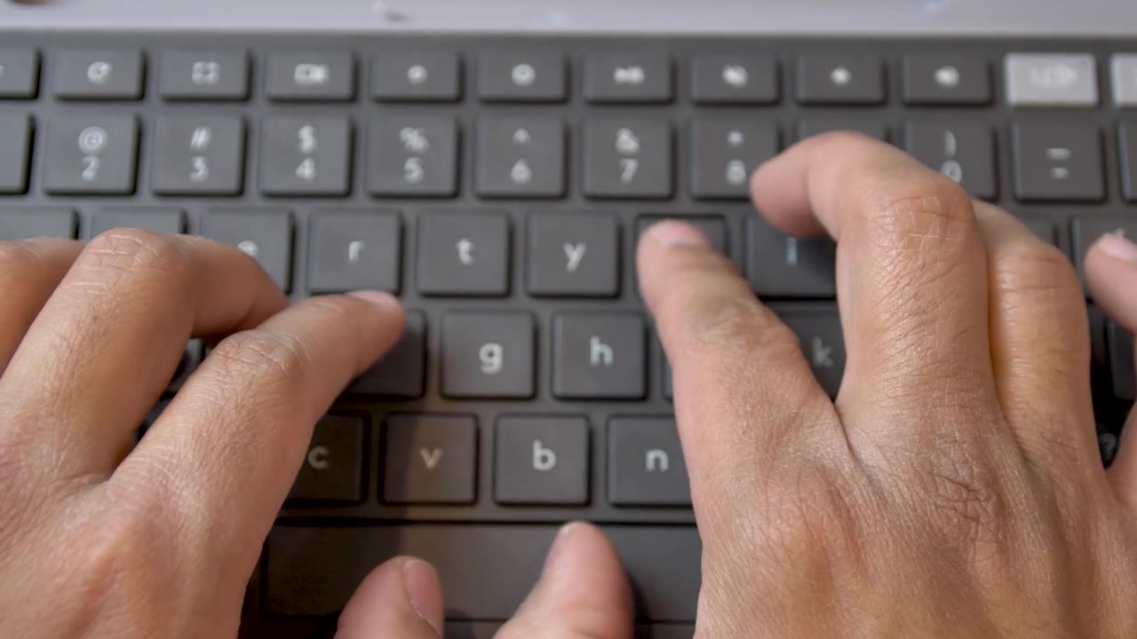 Overhead view of man typing on a keyboard