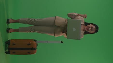 businesswoman celebrating success with laptop and luggage