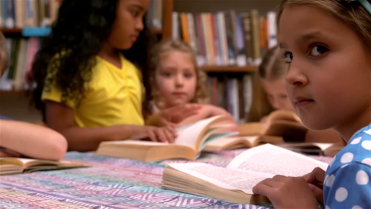 Young class reading books in the library