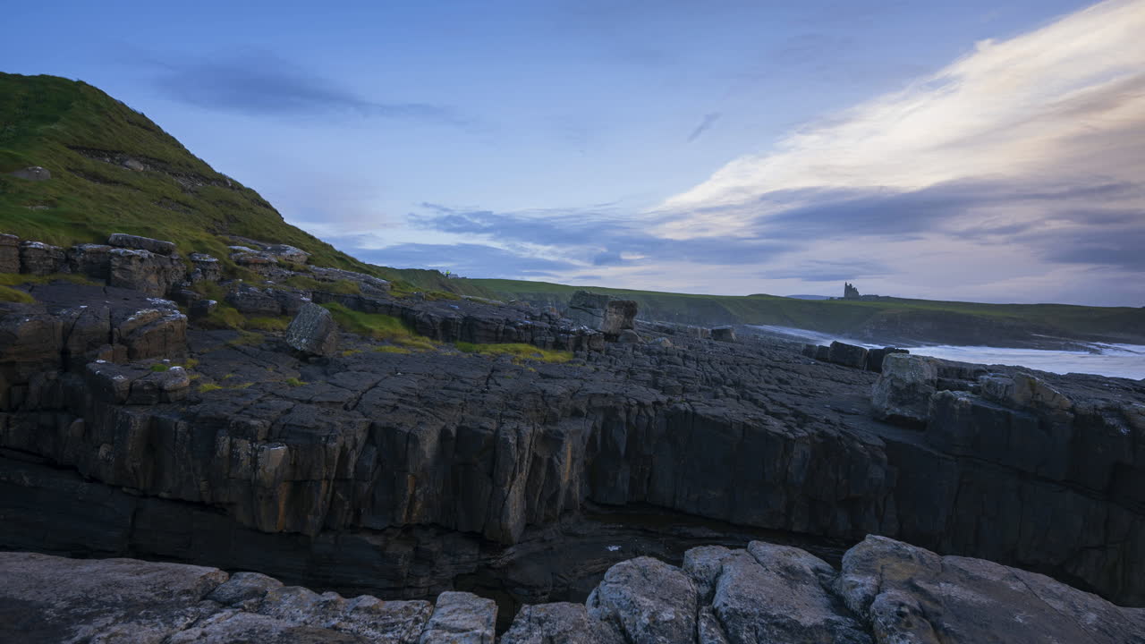lapso de tiempo de escarpados acantilados costeros con nubes en movimiento y castillo de classiebawn en la distancia en mullaghmore head en el condado de sligo en el camino atlántico salvaje en irlanda