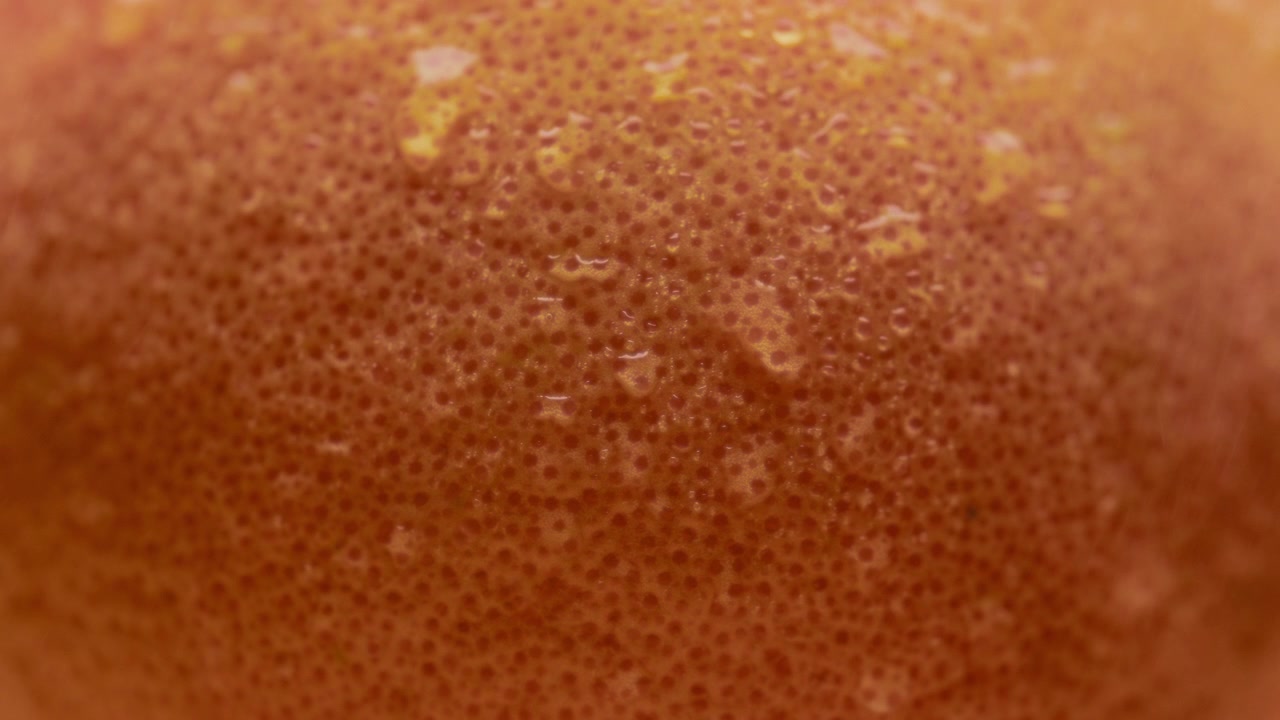 Gotas de agua fluyendo por la superficie de una naranja