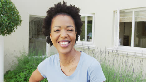 Portrait-of-smiling-african-american-woman-looking-at-camera-in-garden