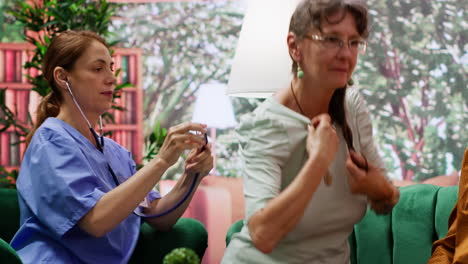 el cuidador escucha los latidos del corazón de una mujer mayor con un estetoscopio
