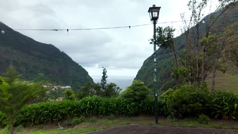 panoramic view of são vicente valley in madeira, with lush green mountains, cloudy skies, and the atlantic ocean visible in the distance