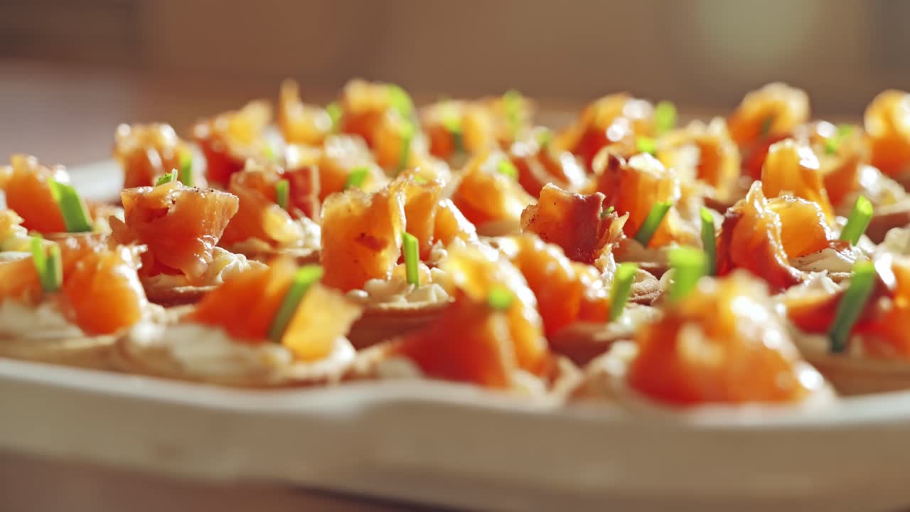 Canapé salmon asap gourmet dengan keju lembut dan adas di atas papan kayu
