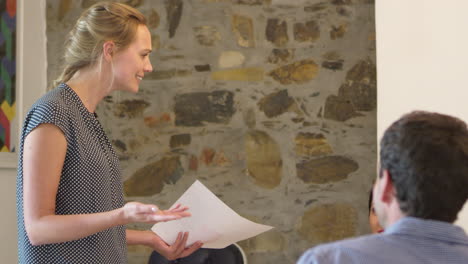 young woman addressing a team meeting in a boardroom