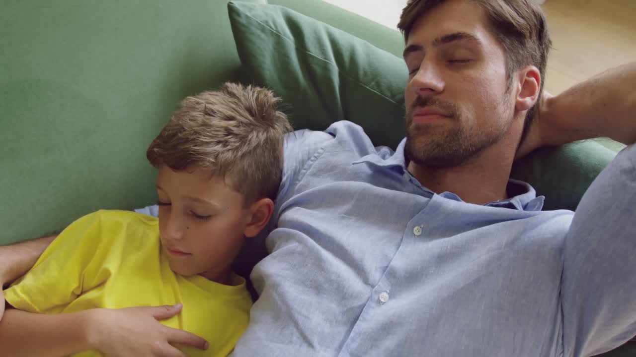 padre e hijo durmiendo juntos en el sofá en casa 4k