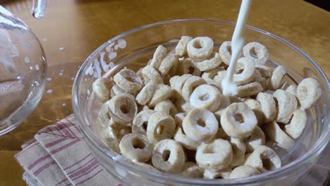 copos de avena crujientes en un tazón para un delicioso desayuno matutino con leche. cámara lenta con toma de seguimiento de rotación.