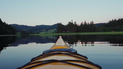 canoe floating at the edge of a beautiful mountain and forest landscape - wide shot