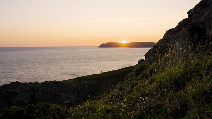 o pôr-do-sol sobre o oceano de um penhasco