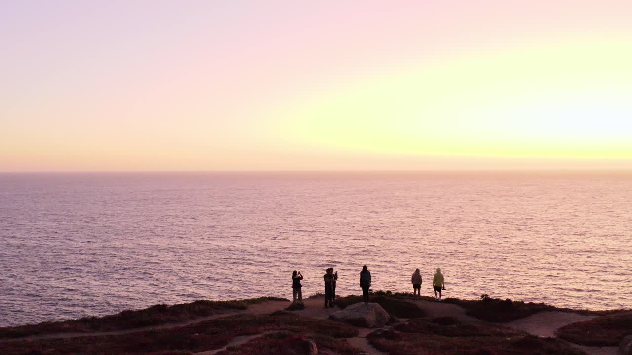 AERIAL: drone, people watching the sunset, steady view