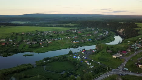 vista aérea de una aldea junto a un río con un festival