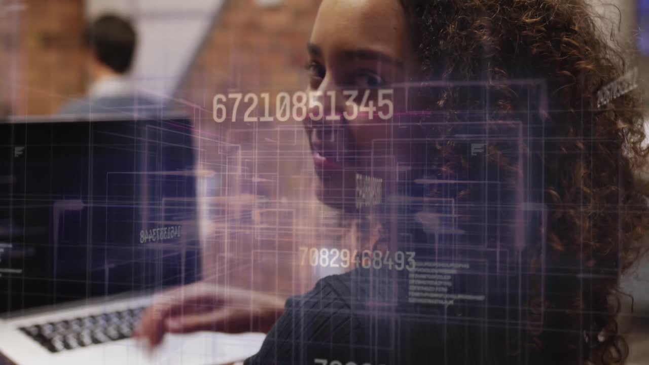 animación de números cambiantes y líneas móviles, mujer biracial trabajando en una computadora portátil en la oficina
