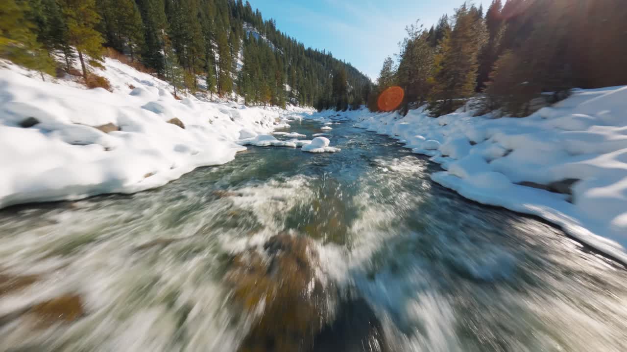fpv bajo volando sobre un río nevado en invierno
