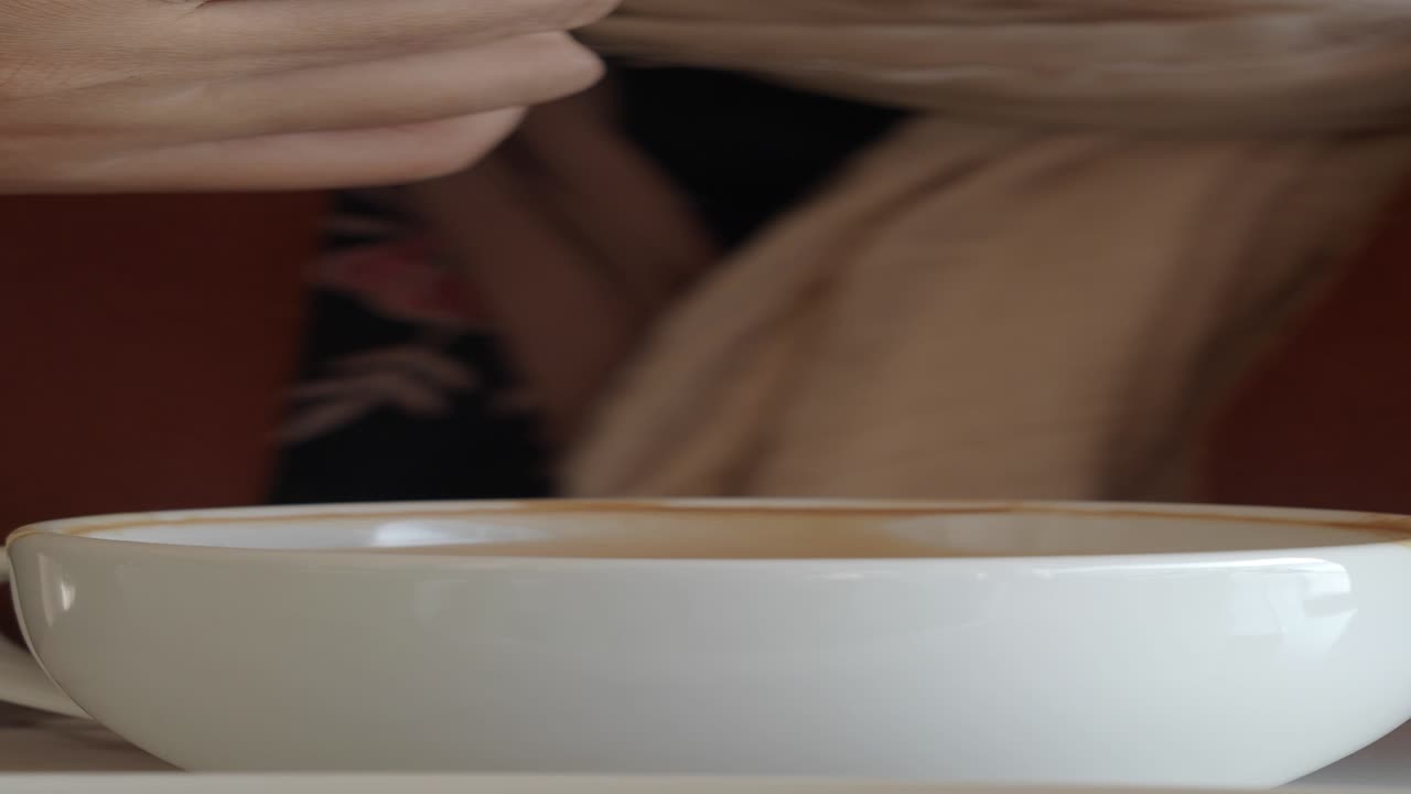 A hand dipping a cookie into a cup of coffee