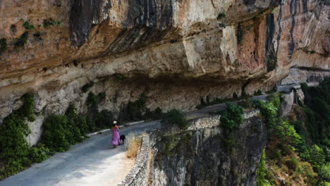 Aerial-follow-shot-woman-walking-her-dog-along-the-Mirador-al-Puente-Romano-Guadalajara