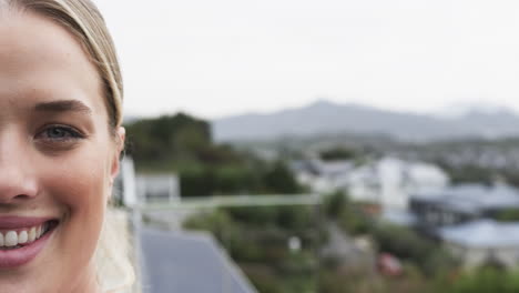 Portrait-of-smiling-caucasian-nurse-on-balcony-with-copy-space,-slow-motion