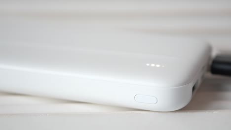 hand holding a white power bank, close up view