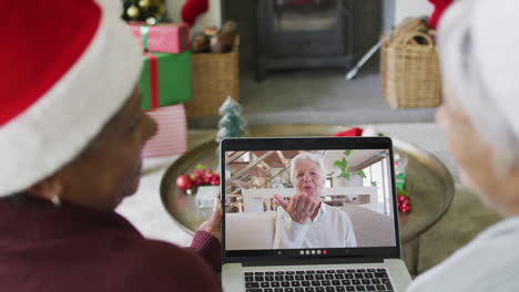 Verschiedene-ältere-Freundinnen-Nutzen-Laptop-Für-Einen-Weihnachtsvideoanruf-Mit-Einer-Glücklichen-Frau-Auf-Dem-Bildschirm