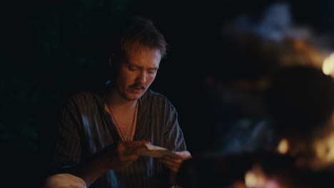 man by campfire at night