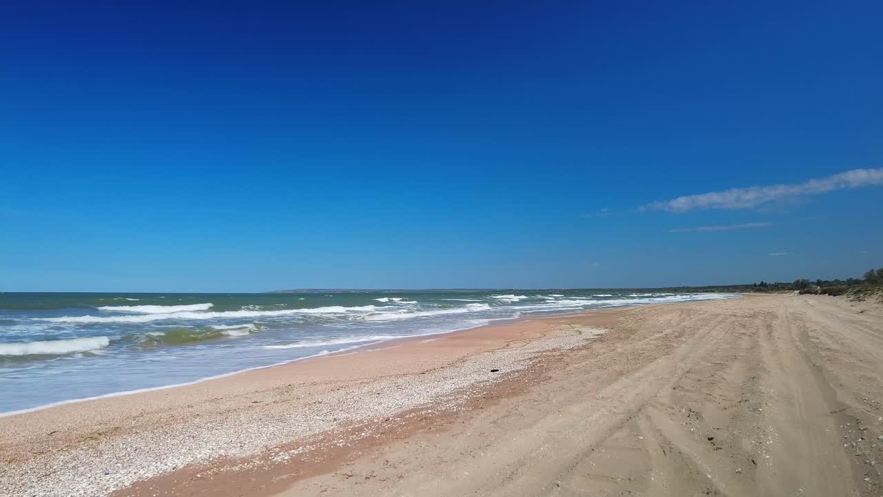 푸른 하늘과 야생 바다를 배경으로 빈 해변 4k