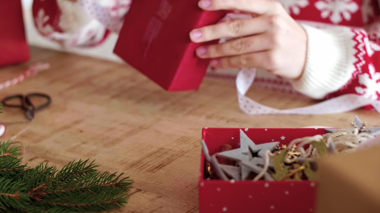Close up of woman's hands wrapping the christmas gifts