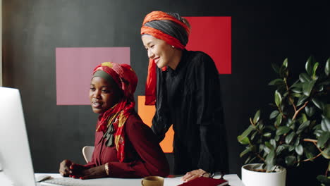 female muslim coworkers working at desk