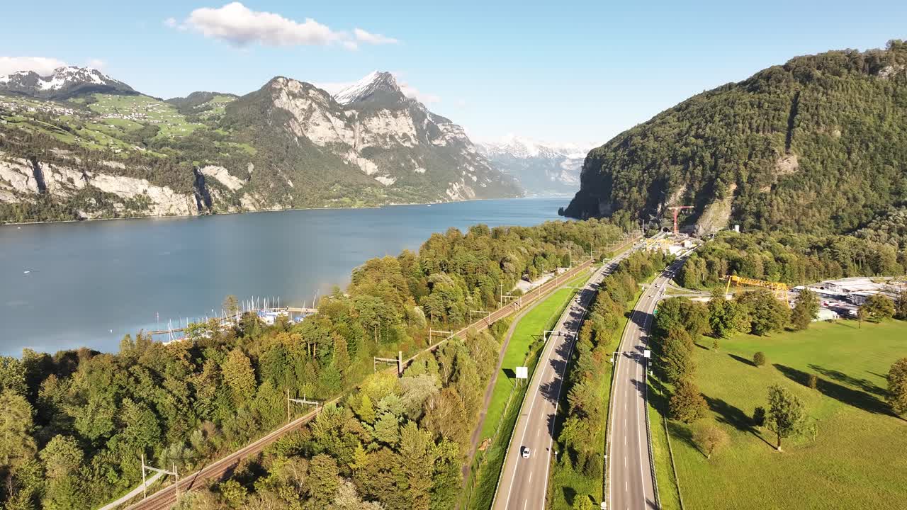 Scenic view of a highway bustling with traffic on a sunny day, near Lake Walensee in Wessen, Glarus Nord, St. Gallen, Switzerland, capturing the lively atmosphere and beautiful surroundings.