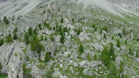 aerial of mountain cable car climbing between rocky slopes, dolomites