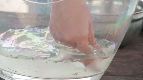 fotografía en cámara lenta de un trabajador de una granja de aloe lavando el gel quitado de una hoja de aloe vera para su procesamiento, de cerca