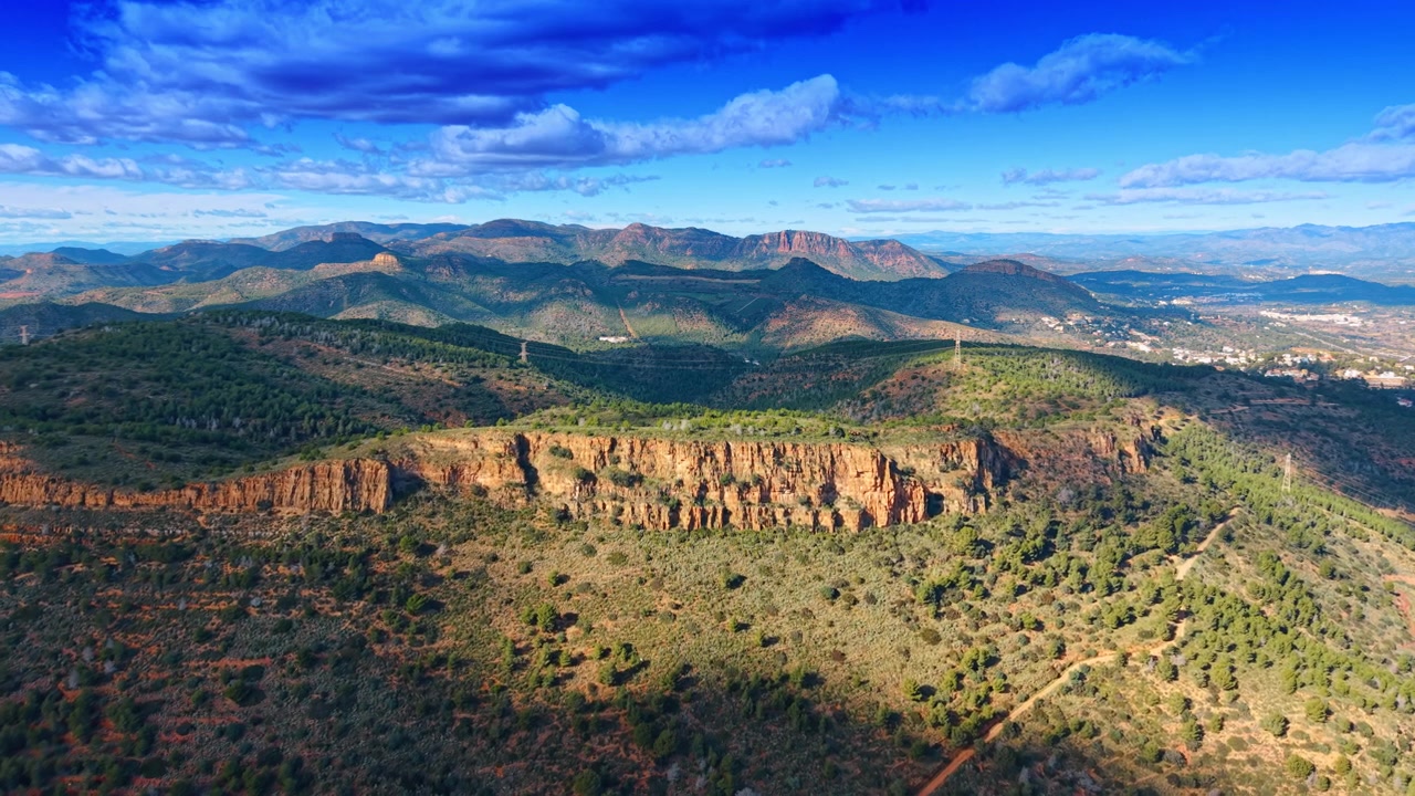 Longue crête rocheuse montagneuse et paysage forestier en Espagne rurale. Vue aérienne d'une falaise rocheuse verticale entourée d'une forêt verdoyante et de chaînes de montagnes lointaines.