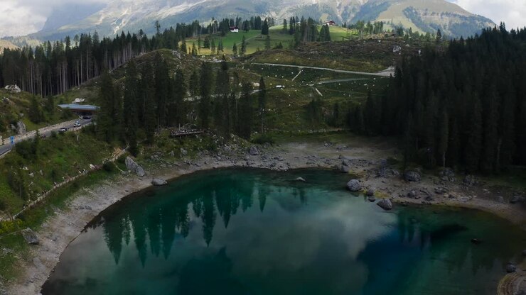 Lago di Carezza in wechselnden Farben, wenn er nicht von der Sonne beleuchtet wird
