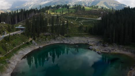 lago di carezza cambiando de color mientras no está iluminado por el sol