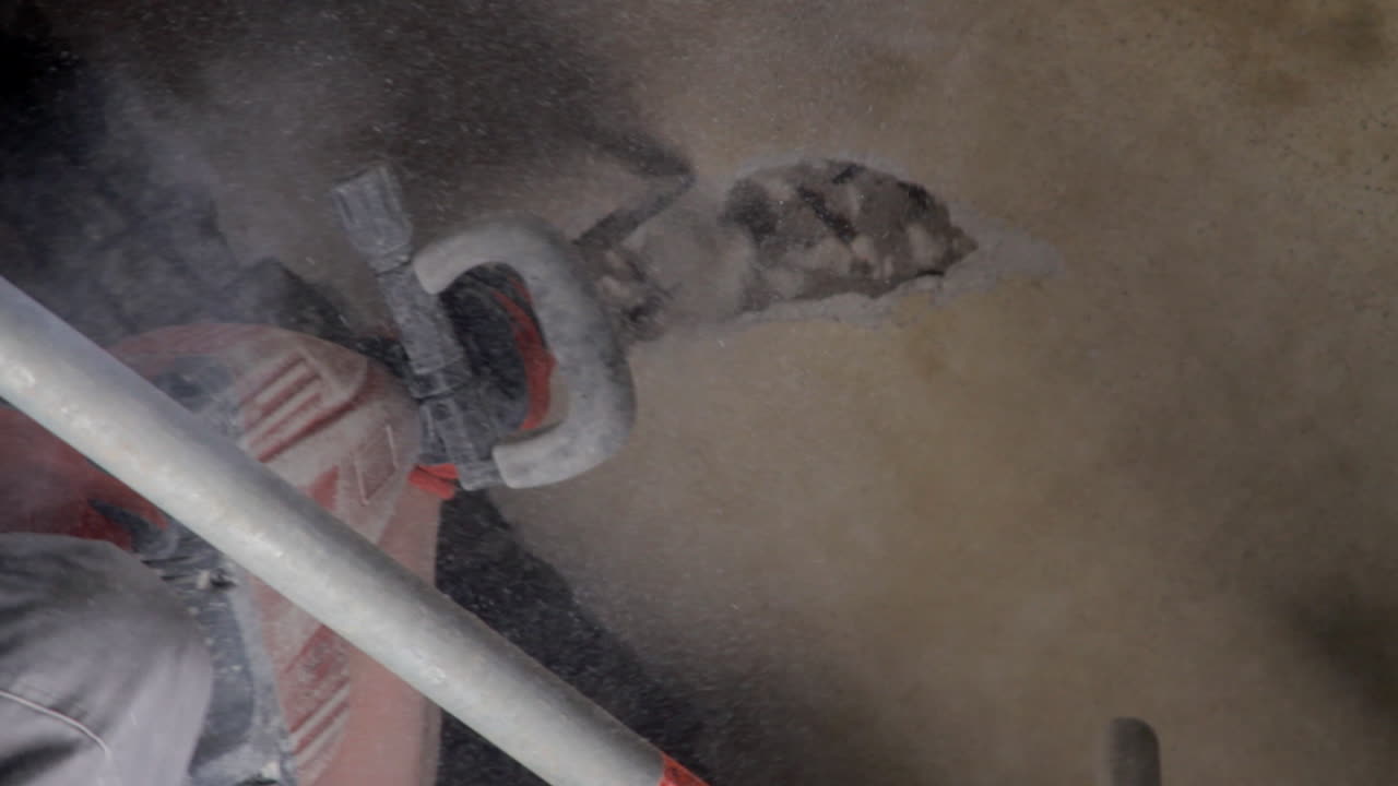 제복을 입은 노동자가 천장 벽을 긁어내고 있다