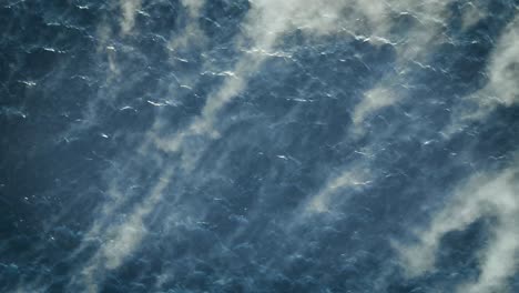 birds eye view of mist and fog being swept over water in norway