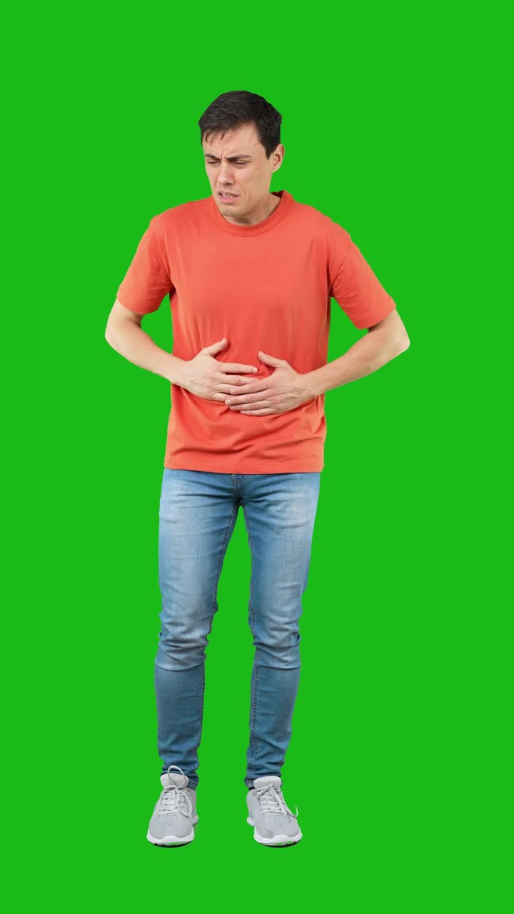 Man suffering from stomach pain and nausea on green screen