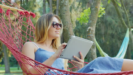 attractive woman rests in a hammock on a summer day 1