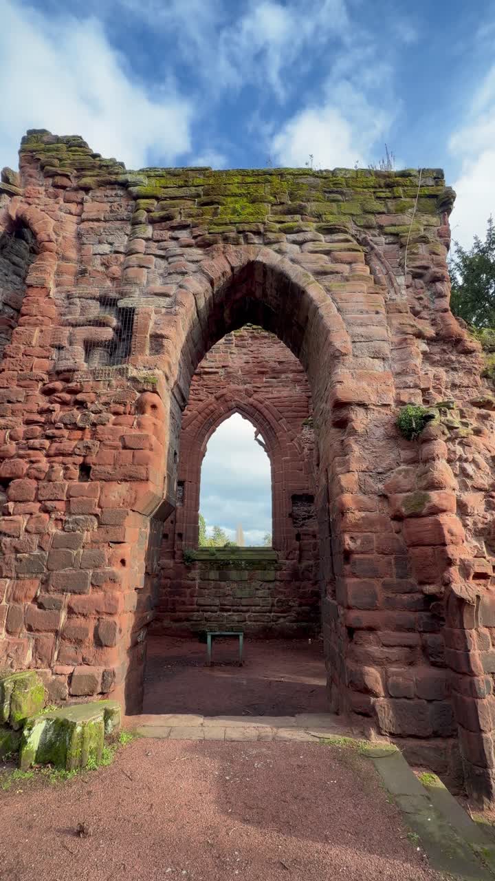 Video verticale per social media di un'alta finestra ad arco in pietra in rovine medievali al Castello di Bolton, Wensleydale, architettura storica con mura in pietra texturizzata e vista sul cielo aperto.