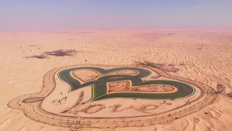 Toma-Aérea-De-Un-Lago-Artificial-En-Forma-De-Corazón-De-Al-Qudra-Dubai-Uae-Desierto-Oasis-Amor-Lago