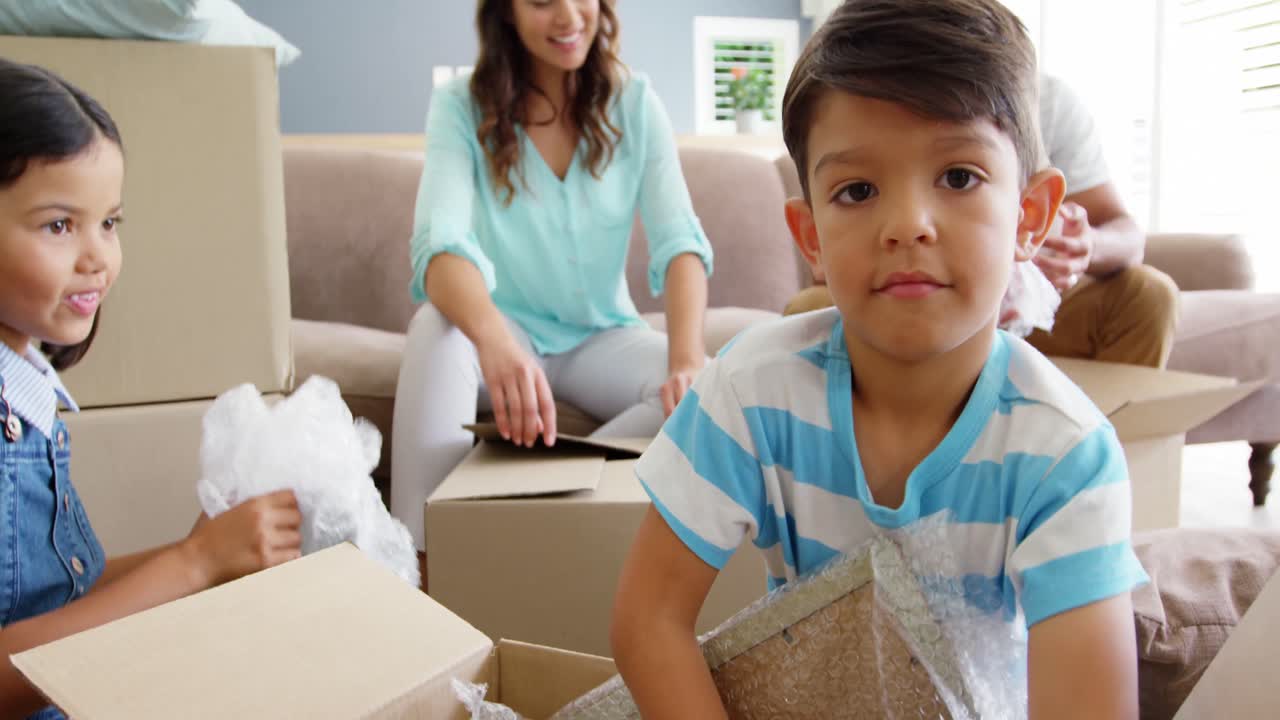 행복 한 가족 이 카드보드 상자 를 풀고 있다