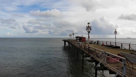 aerial flying beside teignmouth's grand pier reaching out in the english channel