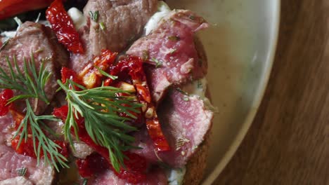 beef steak sandwich with sun-dried tomatoes and herbs