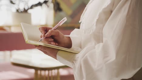 African-american-businesswoman-taking-notes-on-a-notebook,-faceless-profile-shot