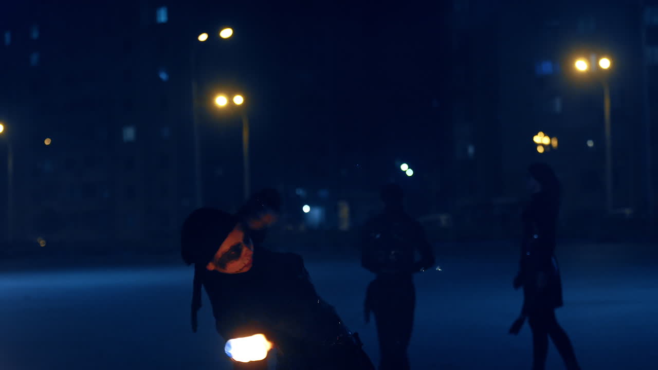 Woman in black costume and artistic makeup dancing with fire. Fire performance outdoors.