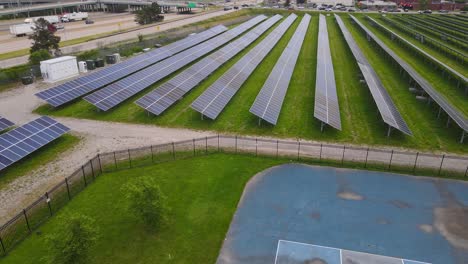 weathered basketball court and new modern solar panel farm, aerial view
