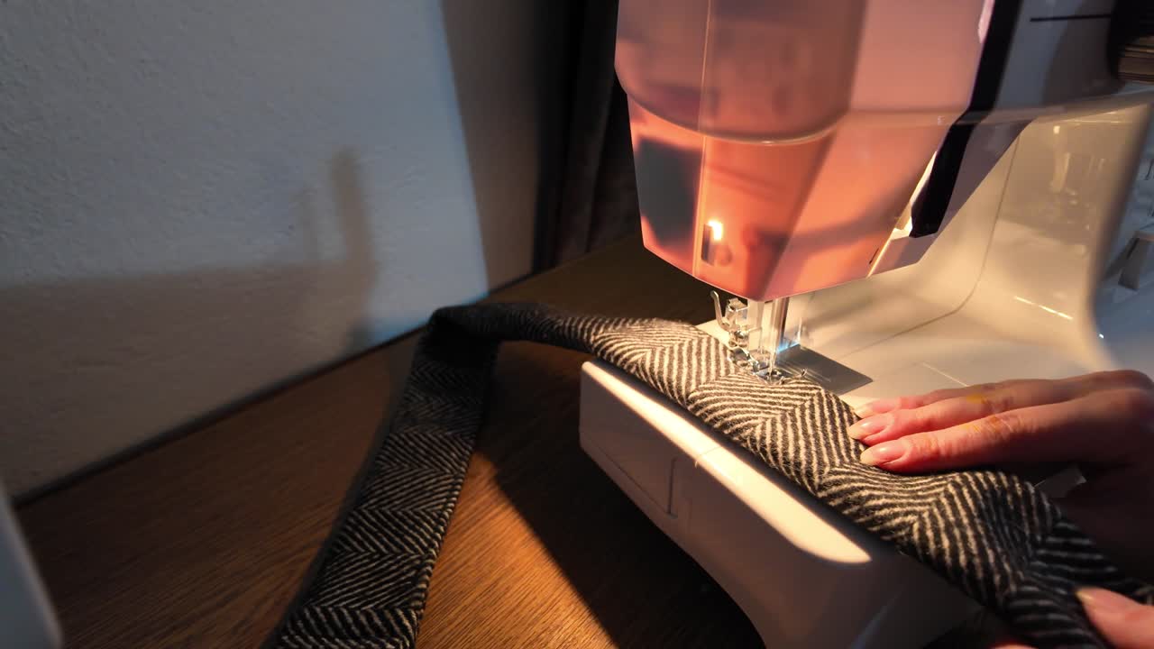 Slow motion tailoring process showing precise edge stitching for a refined coat detail