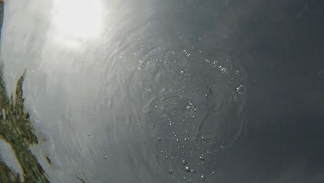 gota de roca en agua clara con reflejo de la luz del sol