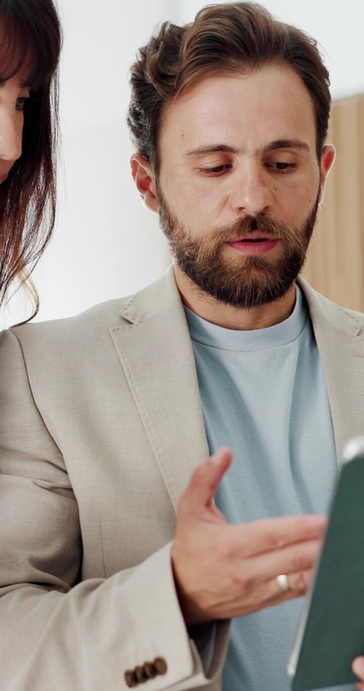 Colleghi di Lavoro che Discutono Dati su Tablet in Ufficio