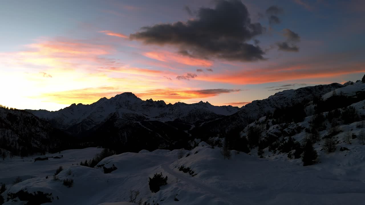 Tramonto maestoso sulle montagne innevate delle Dolomiti della Valmalenco in Valtellina nella stagione invernale, Italia