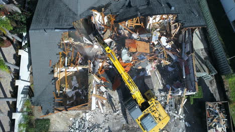 vista de arriba hacia abajo de una demolición de casa con una excavadora